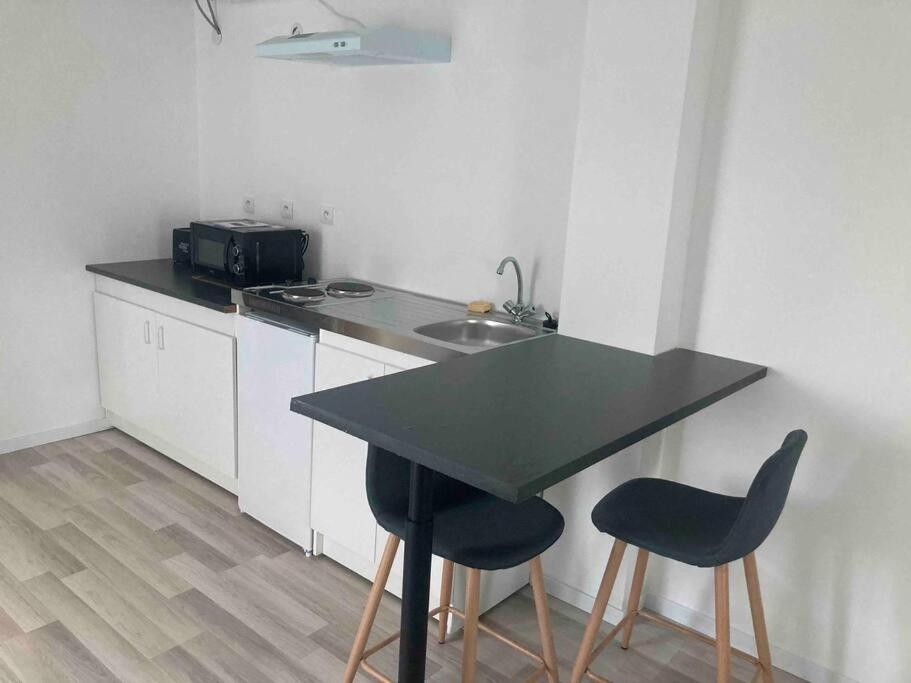 a kitchen with a table and two chairs and a sink at Maisonnette neuve in Saran