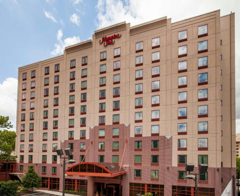 un edificio de hotel con un letrero rojo. en Hampton Inn New York - LaGuardia Airport en Queens