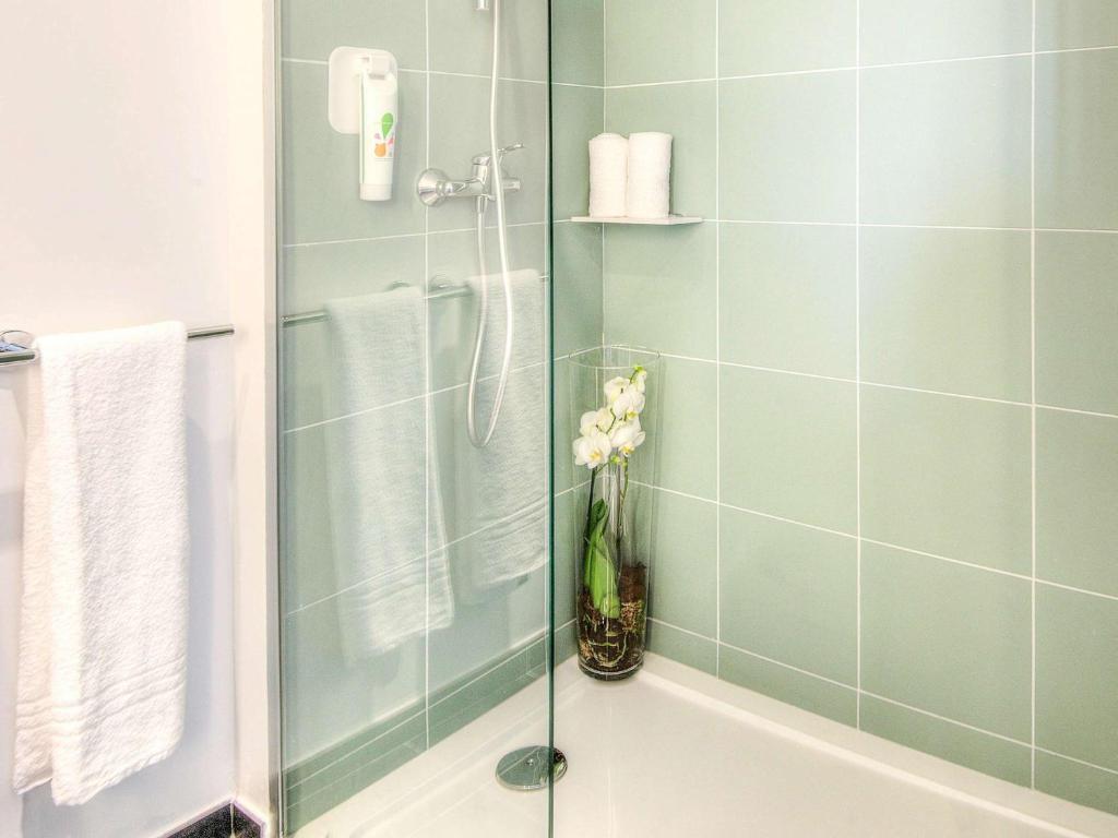 a bathroom with a shower with a vase of flowers at Ibis Styles Nice Centre Gare in Nice