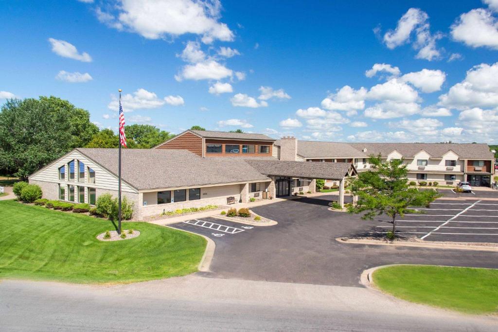 a building with an american flag in a parking lot at AmericInn by Wyndham Eau Claire in Eau Claire