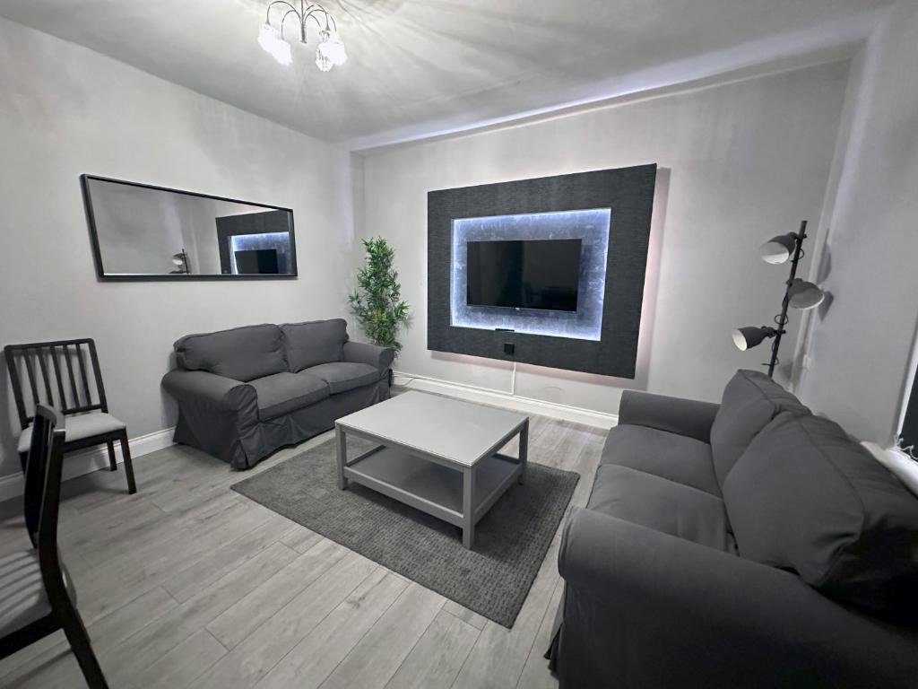 ein Wohnzimmer mit einem Sofa und einem Tisch in der Unterkunft Modernised 3 Bedroom House, Lascelle Residence in Roundhay
