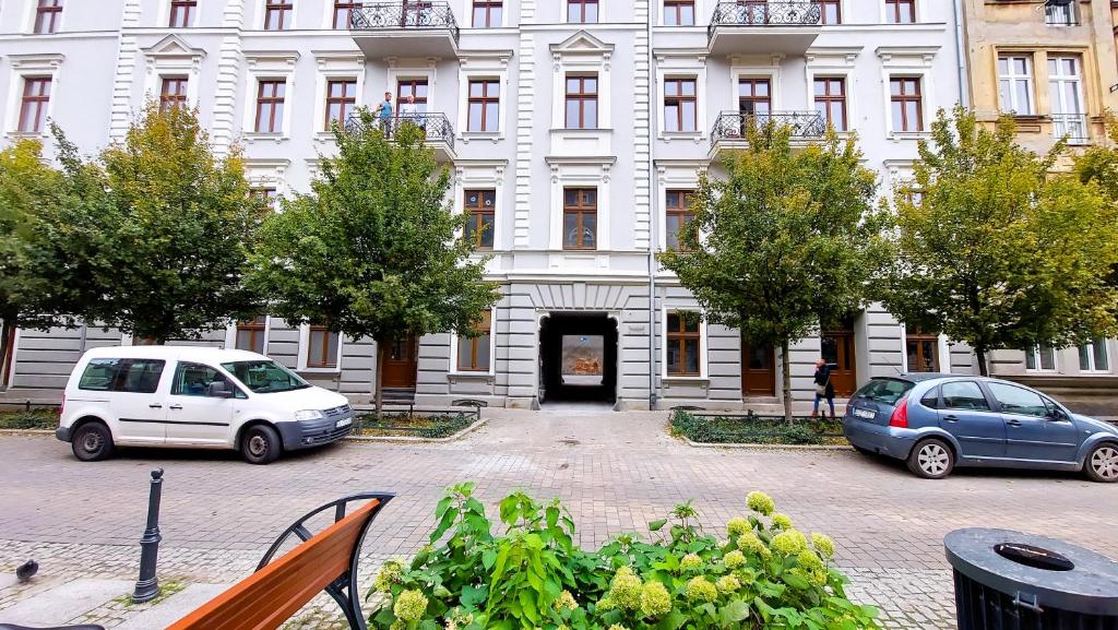 two cars parked in front of a building at theApartments Gdańska in Łódź