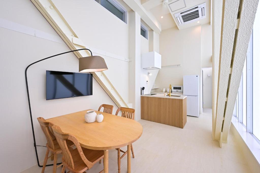 une salle à manger avec une table et une télévision dans l'établissement Totonou & GIVE Nakano Sakaue, à Tokyo