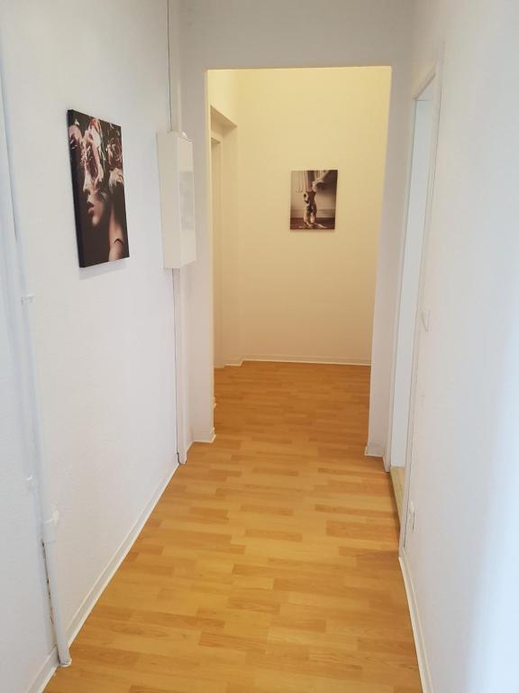 a hallway with two pictures on the walls and a wooden floor at Zimmervermietung Berlin Mertens in Berlin