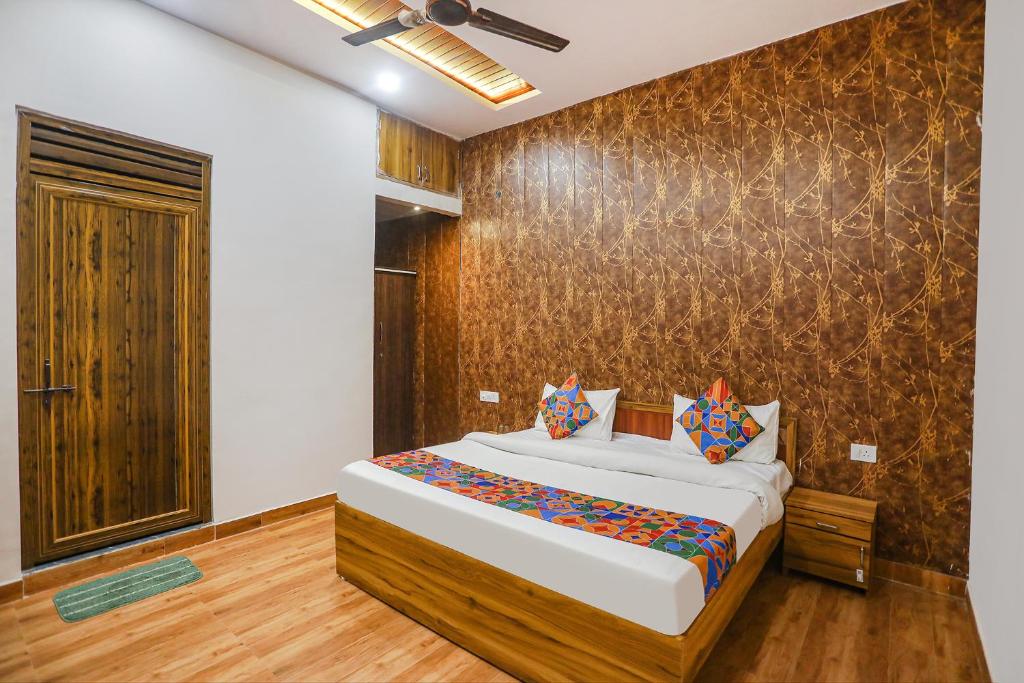 1 dormitorio con cama y pared en FabHotel Moon Gaze Inn, en Kānpur