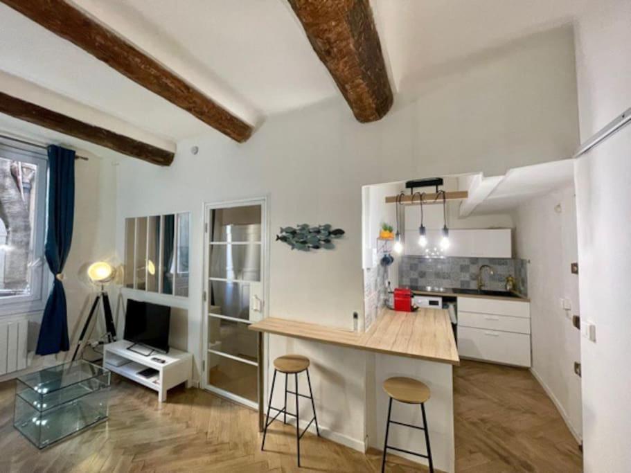 cocina con encimera y taburetes en una habitación en T2 calme centre historique AIX EN PCE, en Aix-en-Provence