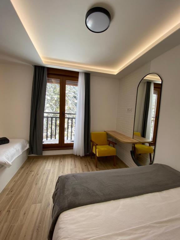 a bedroom with a bed and a desk and a mirror at Apartman Jahorina MD in Jahorina