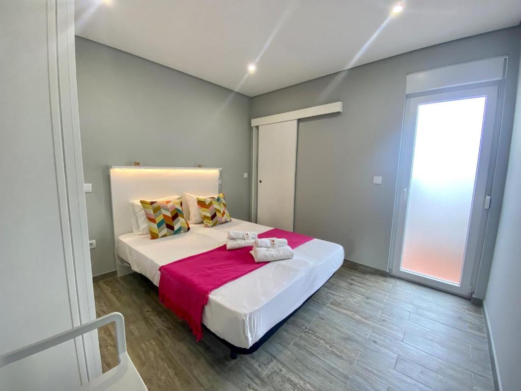 a bedroom with a large bed and a window at Quarteira Stylish 2 by Homing in Quarteira