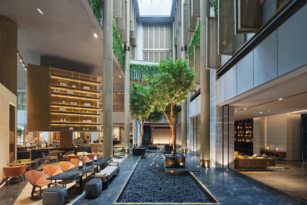 an internal courtyard of a building with tables and chairs at Sheraton Shenzhen Nanshan in Shenzhen