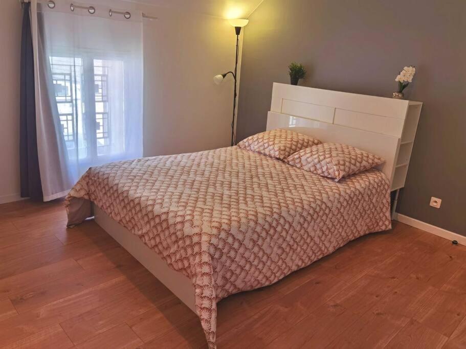 une chambre avec un lit, une lampe et une fenêtre dans l'établissement Maisonnette entière 2 pièces, 30 mn Roissy, 30 mn Disney, à Brégy