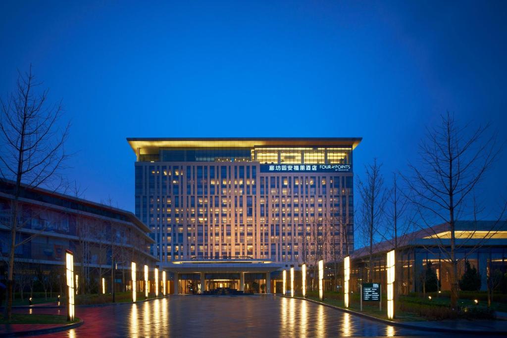 Four Points by Sheraton Langfang, Gu'an في Gu'an: مبنى كبير أمامه أضواء