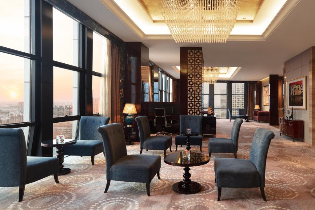 a lobby with chairs and tables and large windows at Sheraton Changzhou Xinbei Hotel in Changzhou