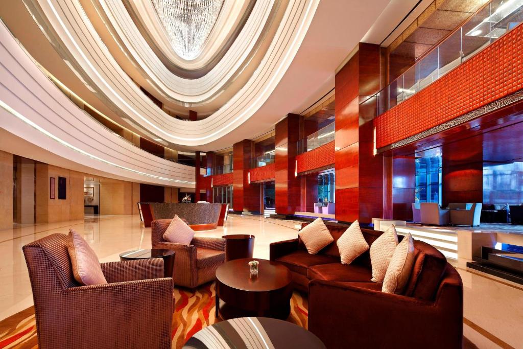 Un vestíbulo con sofás y sillas y una mesa. en Sheraton Jinzhou Hotel, en Jinzhou