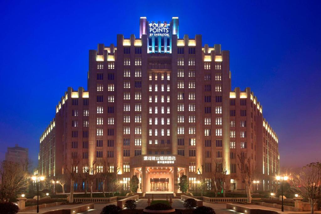 漯河漯河建业福朋酒店（喜来登集团管理）的晚上，建筑物顶部有标志