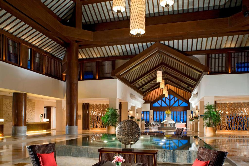 een grote lobby met een zwembad in het midden bij Sheraton Huizhou Beach Resort in Pingshan