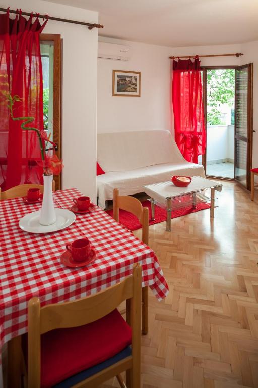 a living room with a table with a red and white table cloth at Kornelija 2 in Podgora