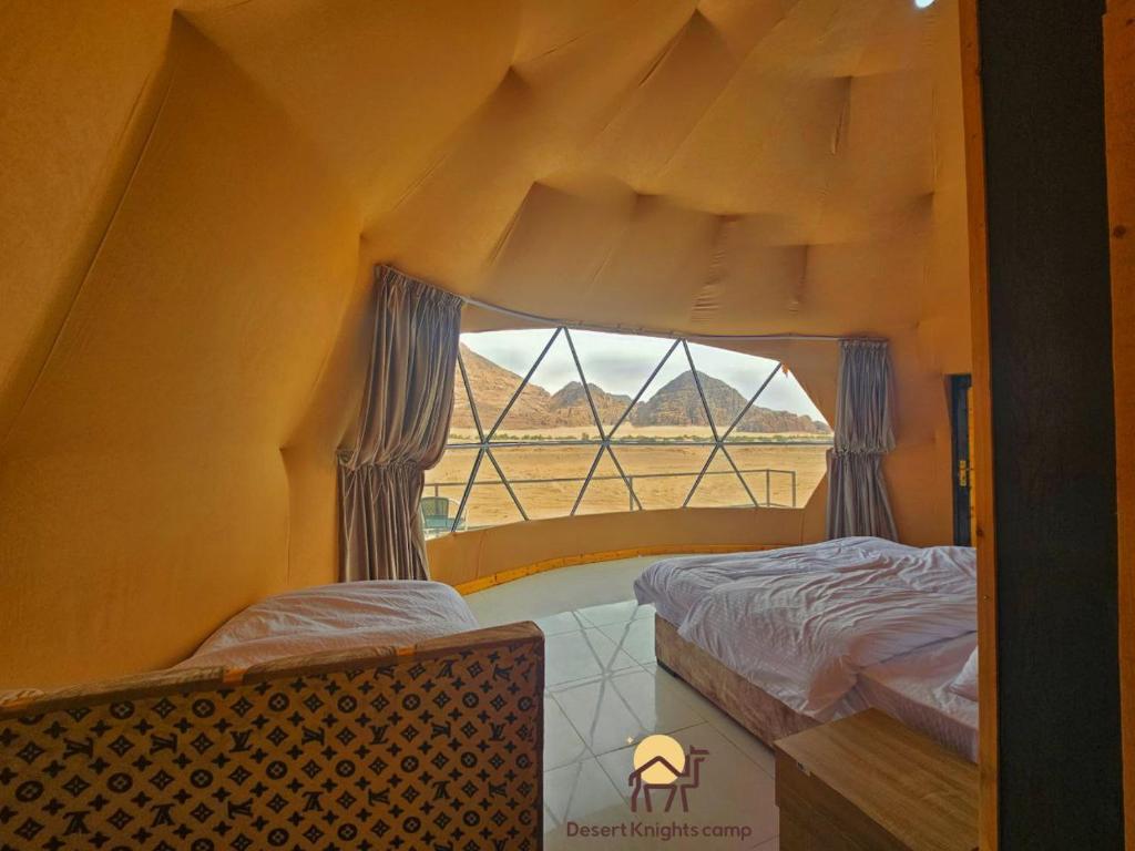 a room with two beds and a window at Desert Knights camp in Wadi Rum