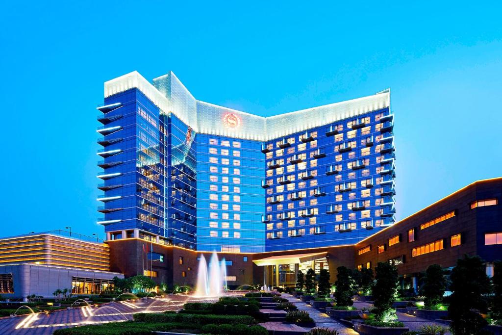 Sheraton Shunde Hotel في شوند: مبنى كبير أمامه نافورة