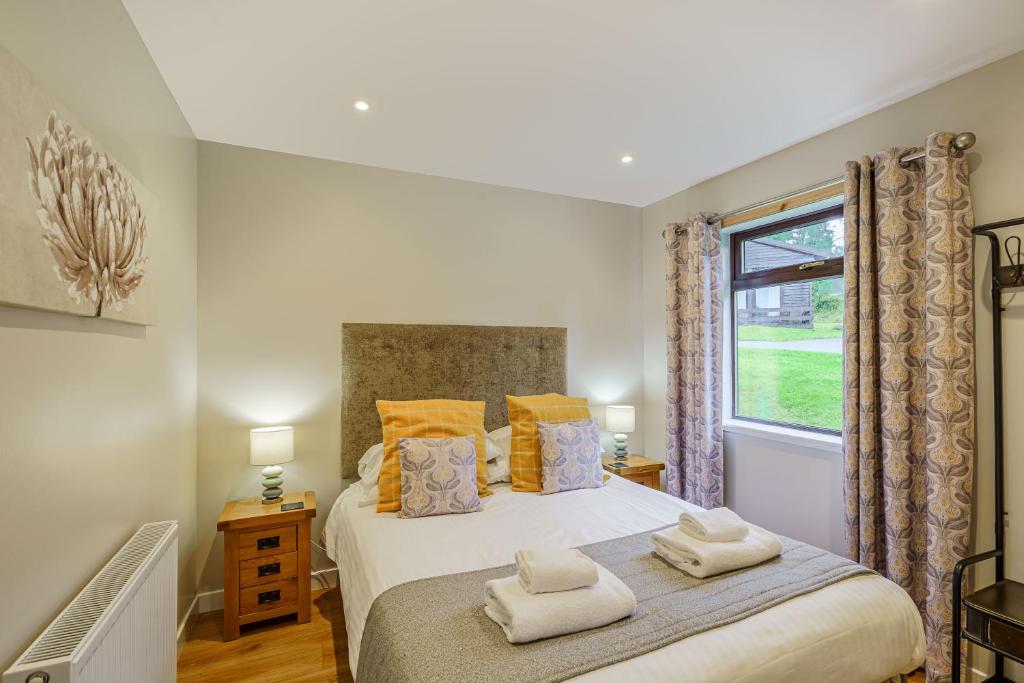 um quarto com uma cama com duas toalhas em Birch Lodge 16 em Newton Stewart