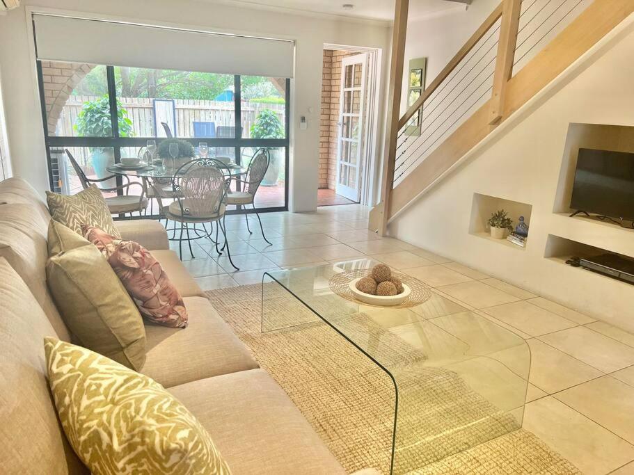 a living room with a couch and a glass table at A touch of lux in the Redlands! in Capalaba