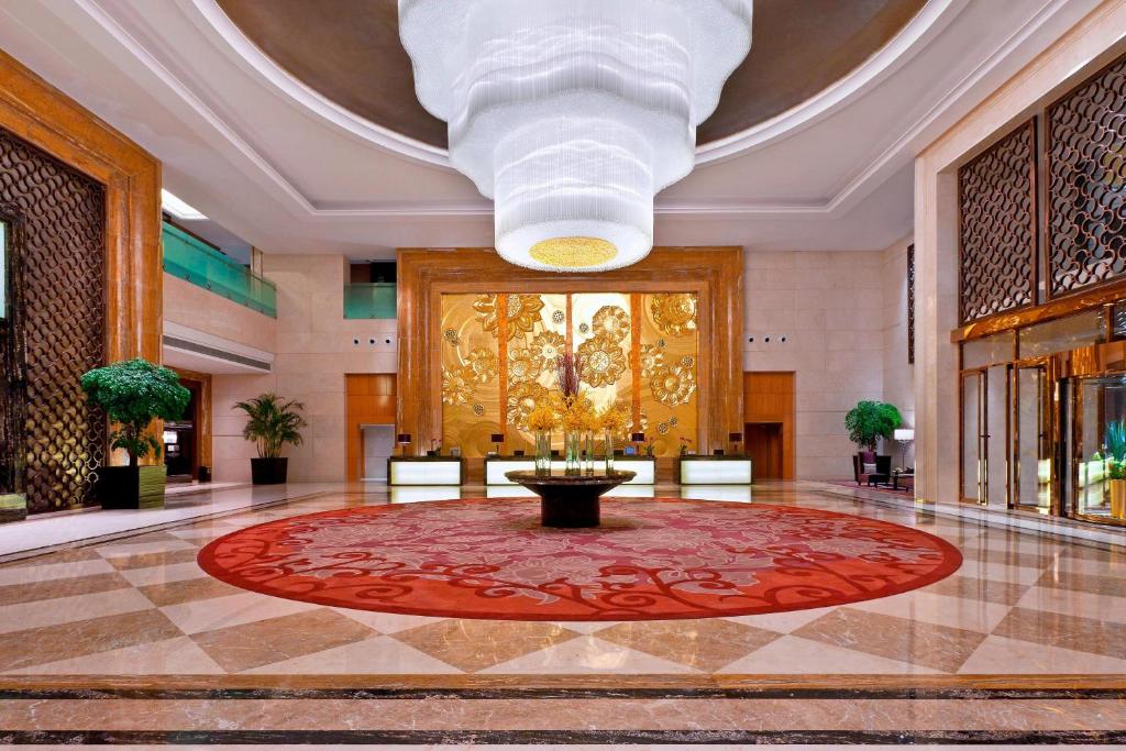 a lobby with a large red rug and a large ceiling at Sheraton Daqing Hotel in Daqing
