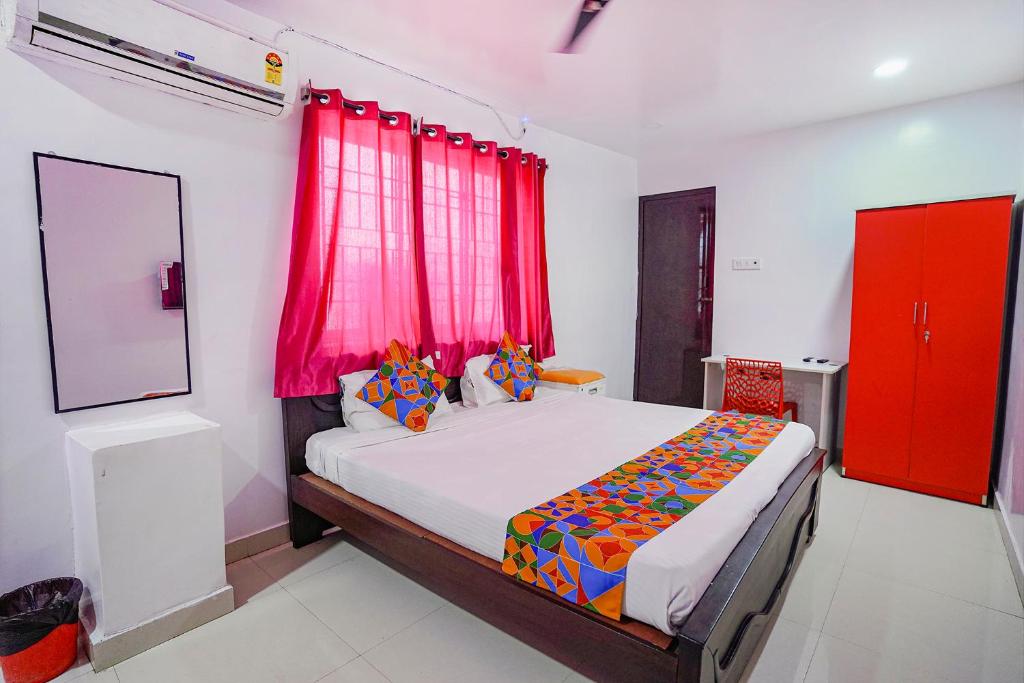 a bedroom with a bed with a red window at FabExpress Lloyds Inn I in Chennai