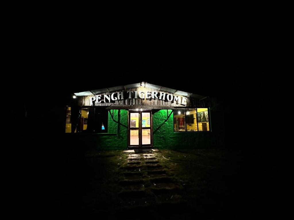 un edificio con un cartel que lee horizontes franceses por la noche en Pench Tiger Home, 