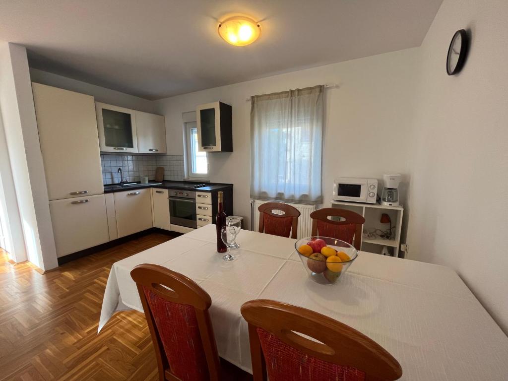 Una cocina con una mesa con un bol de fruta encima. en Burle Apartment with FREE private parking, en Medulin