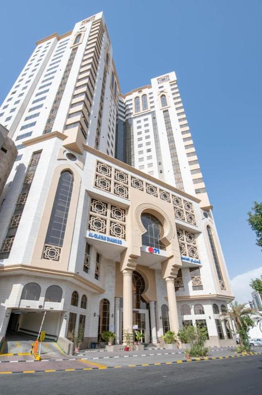 a large white building with tall buildings at Alolayan Diamond Hotel in Mecca
