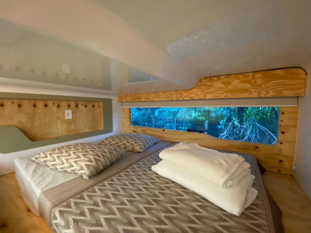 a bedroom with a large bed with a window at Green Garden Foz - Casas e Lofts em um Bosque in Foz do Iguaçu