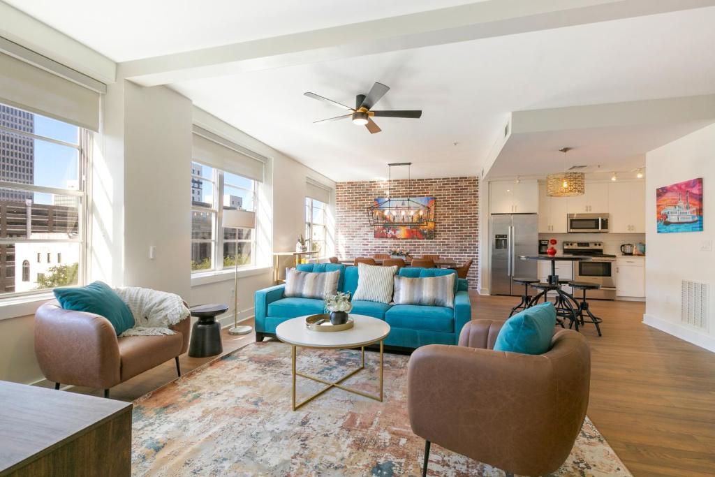 sala de estar con sofá azul y sillas en French Quarter Oasis: Spacious 4-Bedroom Condo, en Nueva Orleans