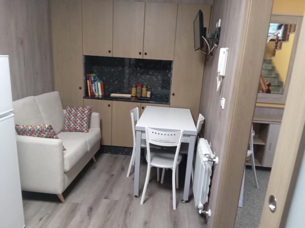 a living room with a table and a couch and a kitchen at CarreraHouses OCouto in Pontevedra