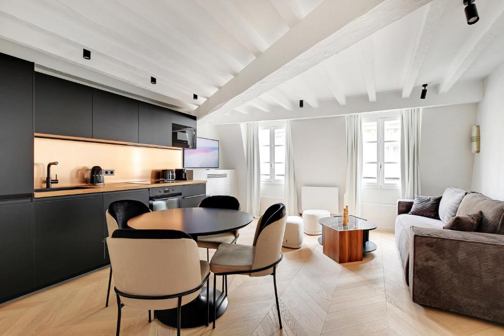une cuisine et un salon avec une table et des chaises dans l'établissement Pick A Flat's Apartement in Saint-Germain-des-Prés - Rue de Seine, à Paris