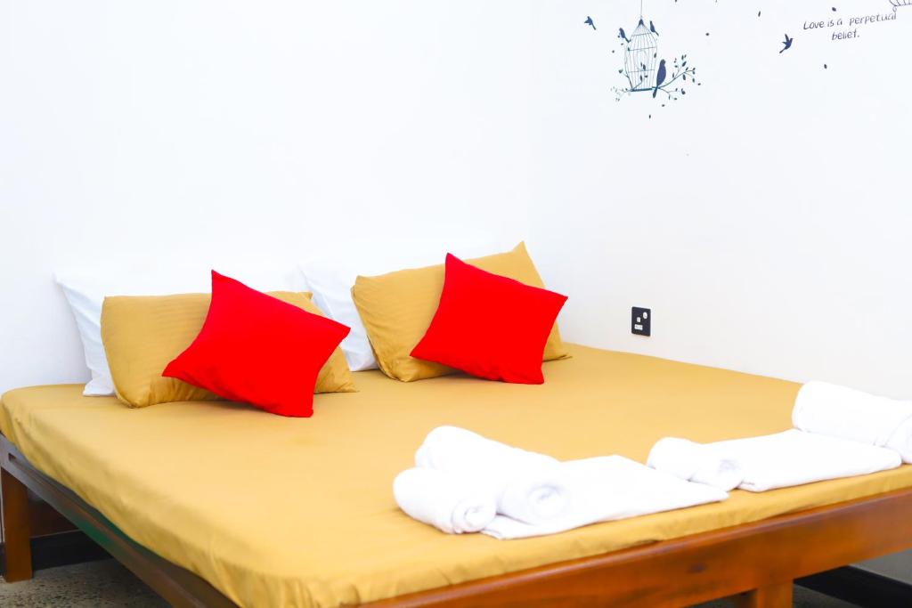 a bed with red and white pillows on it at Royal Hub in Negombo