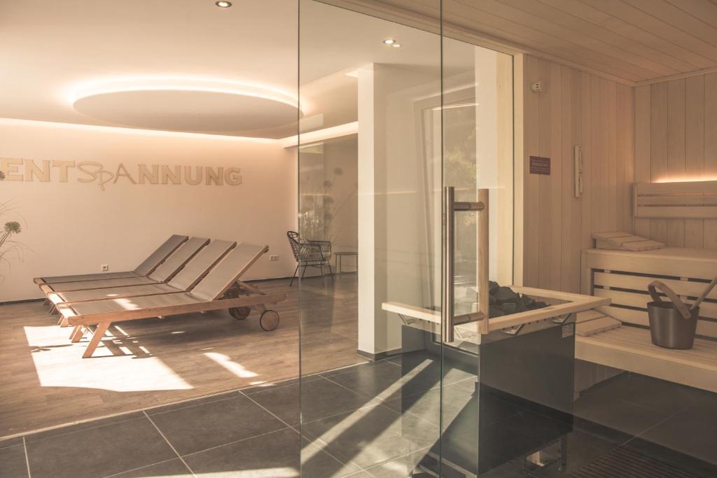 ein Zimmer mit einem Stuhl und einer Bank in einem Zimmer in der Unterkunft Boutique Wellnesshotel Landmann in Steinen