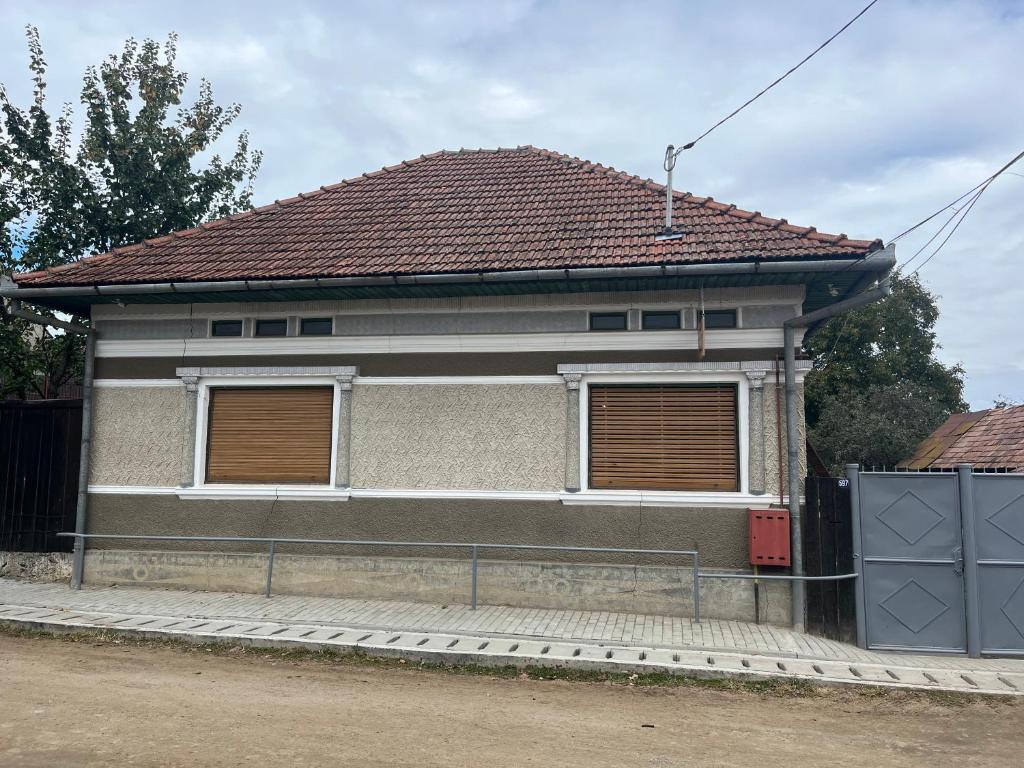 una casa con techo rojo y 2 ventanas en CASA LUCIAN, en Cârţişoara