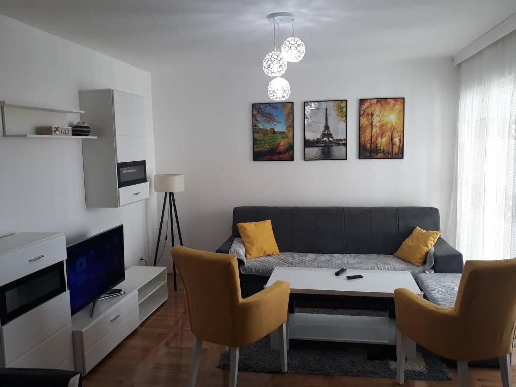 een woonkamer met een bank en een tafel bij Apartman See in Bijeljina