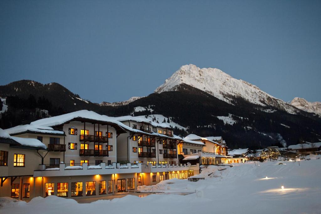 ein Hotel im Schnee mit einem Berg im Hintergrund in der Unterkunft ROBINSON AMADÉ in Kleinarl