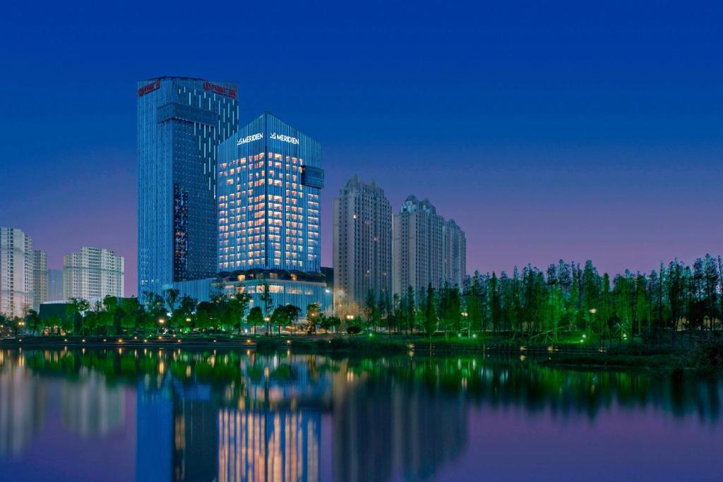 een skyline van de stad met hoge gebouwen en een waterlichaam bij Le Méridien Yixing Hotel in Yixing