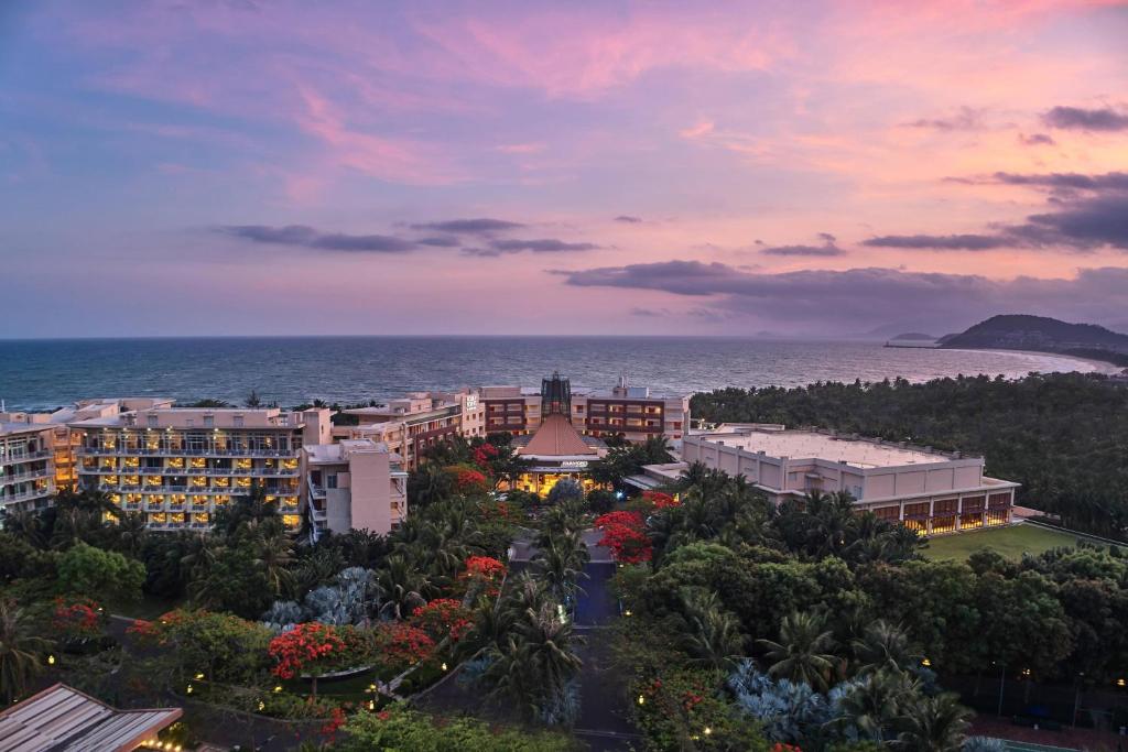 una vista aérea de un complejo y del océano al atardecer en Four Points by Sheraton Shenzhou Peninsula Resort en Wanning