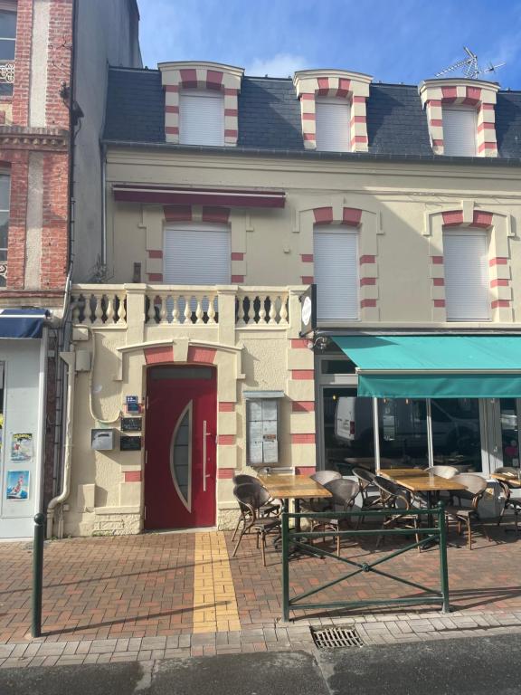 ein Gebäude mit einem Tisch und Stühlen davor in der Unterkunft Laugann's Home in Cabourg