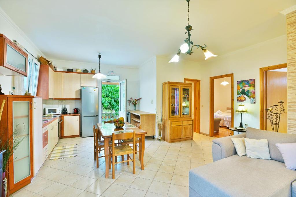 eine Küche und ein Wohnzimmer mit einem Tisch und einem Sofa in der Unterkunft Drossos Garden House in Nydri