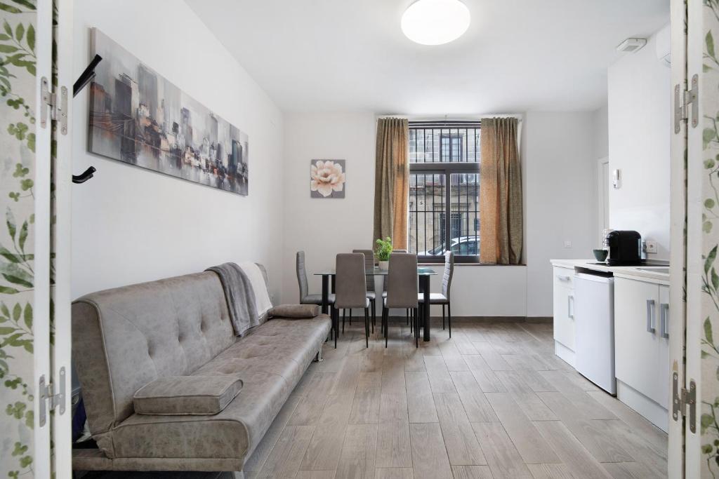 una sala de estar con un sofá y una mesa en Apartamentos Centro Jerezano 2, en Jerez de la Frontera