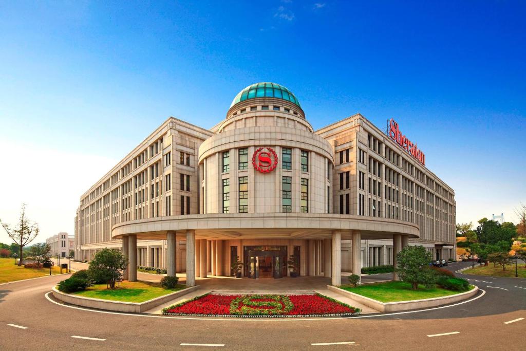 un gran edificio blanco con un letrero rojo. en Sheraton Jiangyin Hotel, en Jiangyin