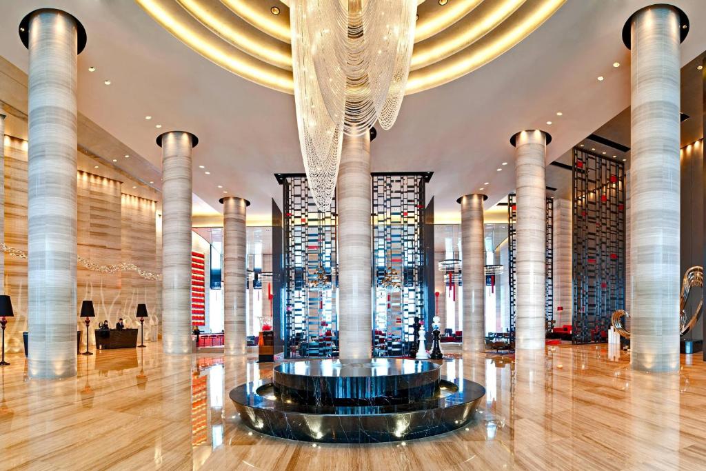 een grote lobby met een grote kroonluchter in een gebouw bij Le Meridien Chongqing Nan'an in Chongqing