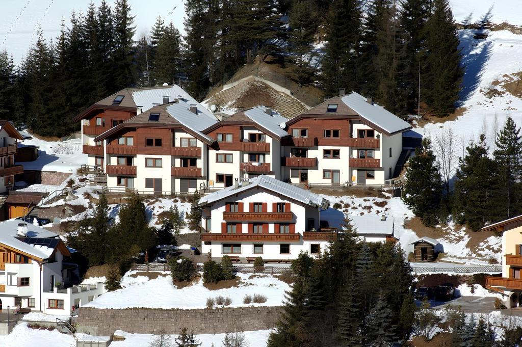 un grupo de edificios en una montaña cubierta de nieve en Apartments Boè, en Santa Cristina Valgardena