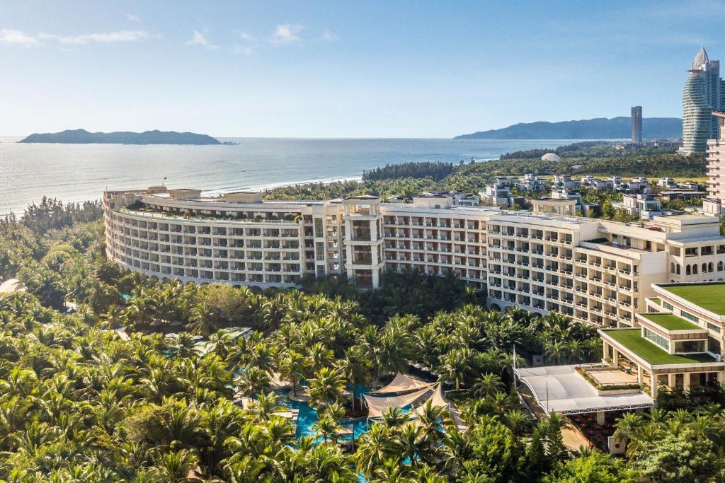 Sheraton Sanya Haitang Bay Resort في سانيا: اطلالة جوية على المنتجع مع المحيط في الخلفية