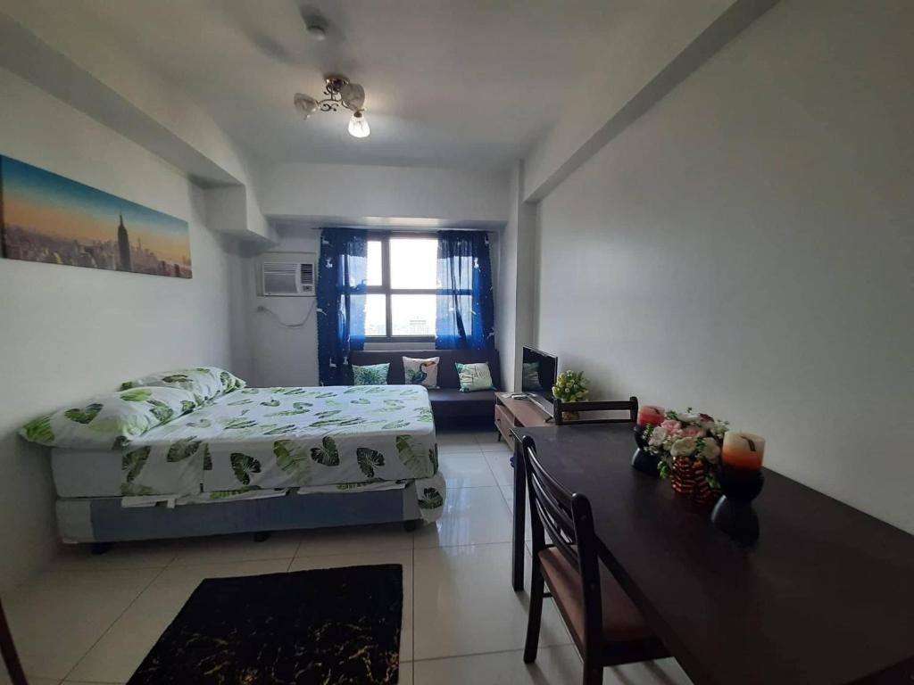 1 dormitorio con cama, mesa y escritorio en Horizons 101 Condominium en Cebu City