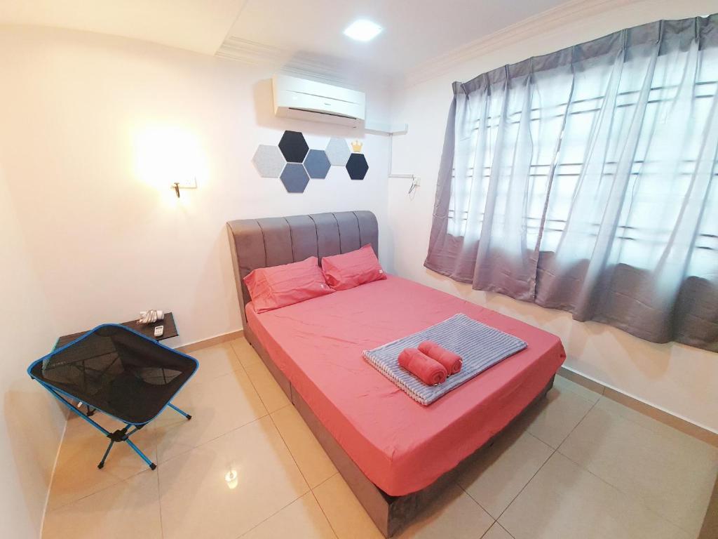 ein kleines Schlafzimmer mit einem roten Bett und einem Fenster in der Unterkunft Lot 90 Seremban Town Homestay in Seremban