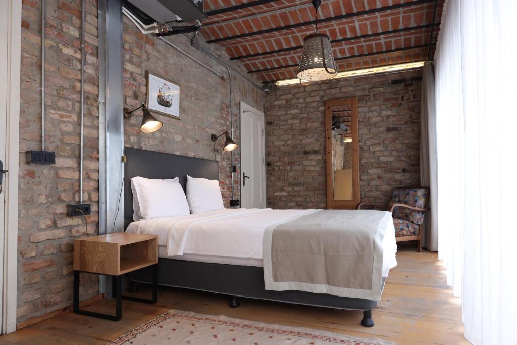 a bedroom with a large bed in a brick wall at Novus Pera Hotel in Istanbul